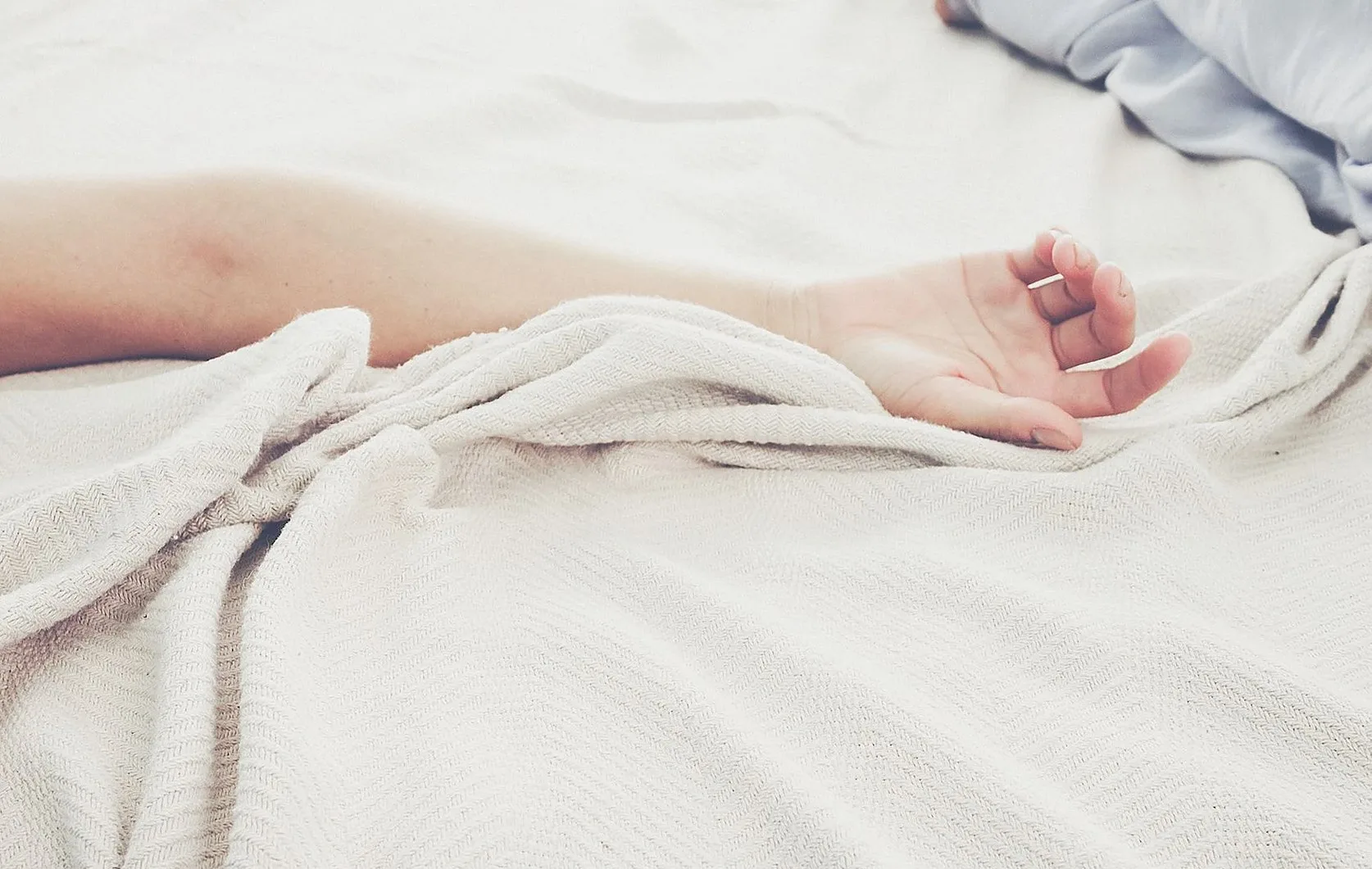 淡い色の布の上に置かれた手